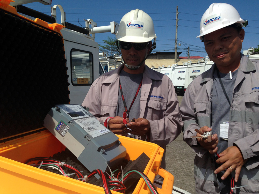 Technician Niceporo Salvaleon, Jr. and meter engineer Alvin Basubas shows the power meter tester that they built for about P25,000 to do the job previously done by a machine that costs about P1.9 million.